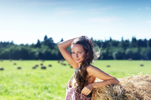 Девушка рядом с стопкой сена — стоковое фото