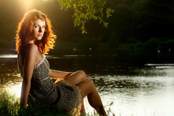Lány ül folyó közelében — Stock Fotó