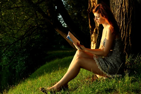 Vrouw lezen van een boek in park — Stockfoto