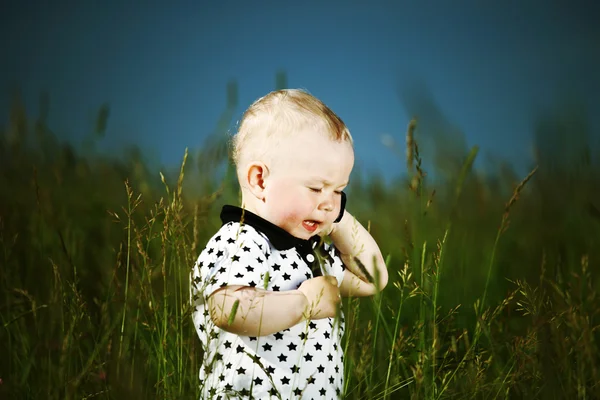 Chlapec v trávě zavolat telefonicky — Stock fotografie