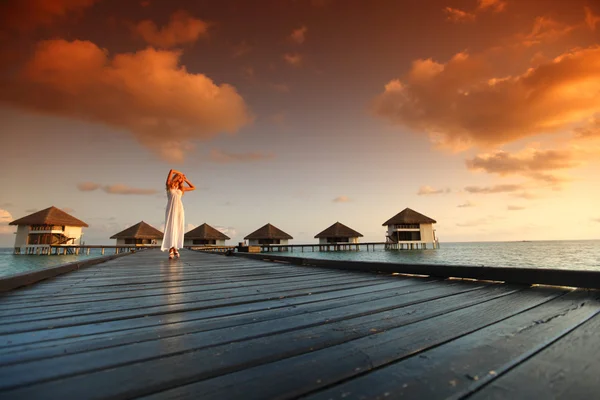 Vrouw in een jurk op Maldivische zonsondergang — Stockfoto