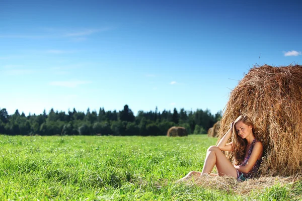 Chica al lado de una pila de heno — Foto de Stock