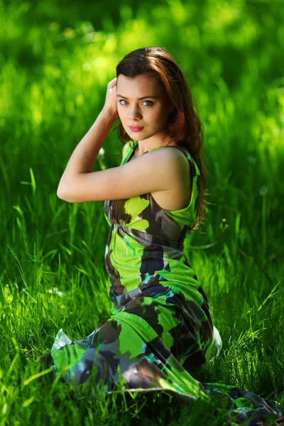 Brunette assise sur herbe verte — Photo