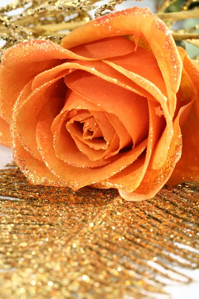 Orange Rose mit goldener Dekoration Stockbild