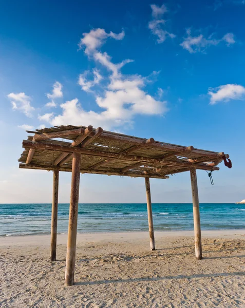 stock image Wooden canopy on the sandy beach and blue sky