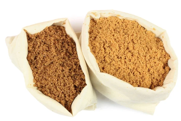 Dois tipos de açúcar mascavo em sacos de tecido branco . — Fotografia de Stock