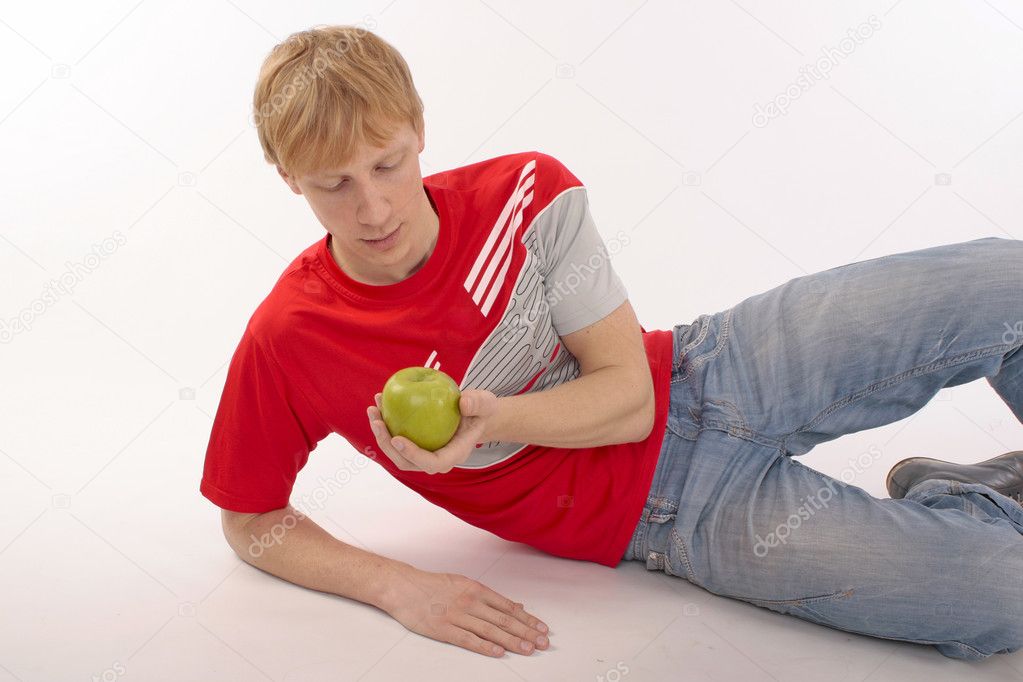 Young man in a red t-shirt holding a green apple