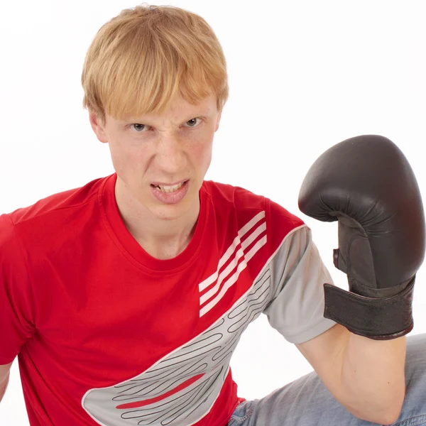 Angry young man in een rode t-shirt met een bokshandschoen — Stockfoto