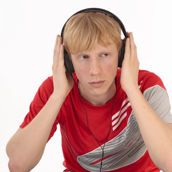 Upset young student hearing music on white — Stock Photo, Image