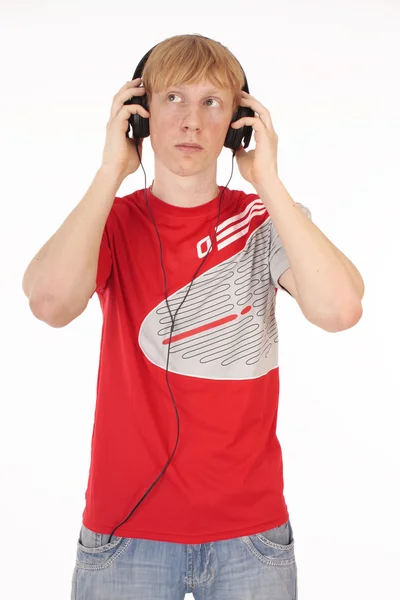 Νεαρός άνδρας σε το κόκκινο μπλουζάκι με ακουστικά σε λευκό φόντο — Φωτογραφία Αρχείου