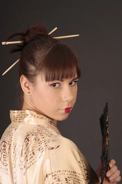 Belle jeune femme geisha en costume asiatique avec ventilateur asiatique — Photo