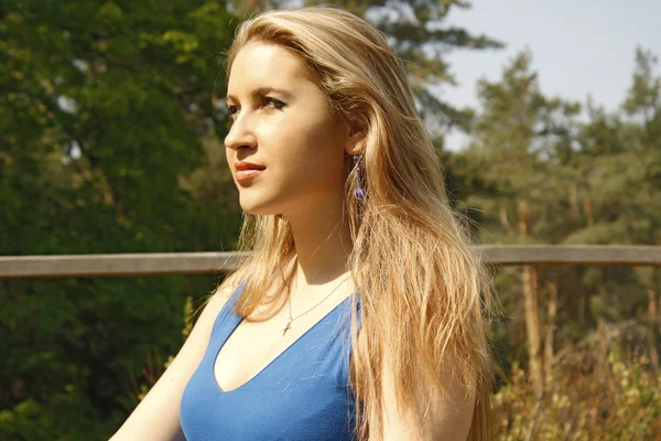 Mavi bir bahar bahçe içinde güzel bir kadın — Stok fotoğraf