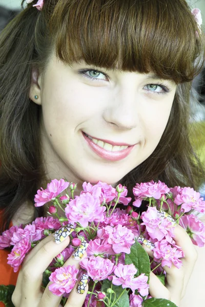 stock image The portrait of the happy cheerful girl with pink flowers