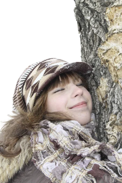 A menina bonita aninhou uma bochecha em um tronco de árvore — Fotografia de Stock