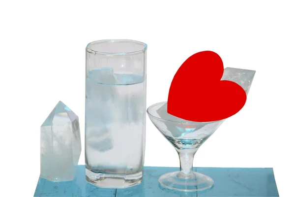Um copo de água com cubos de gelo um cristal e coração — Fotografia de Stock