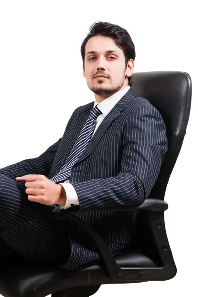 Selbstbewusster Geschäftsmann sitzt auf Bürostuhl — Stockfoto
