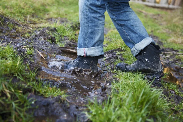 stock image Man walking through mud