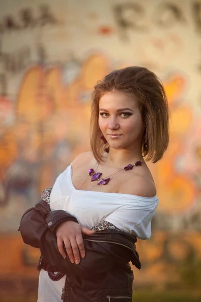 Urban portrait of the girl on the background graffiti — Stock Photo, Image