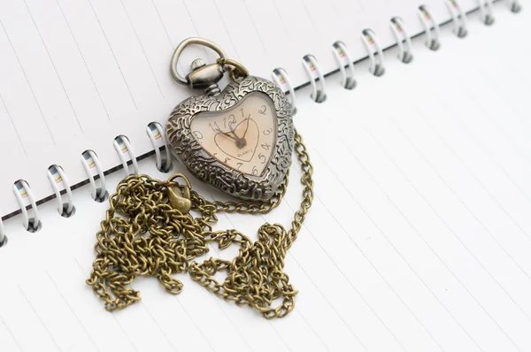 Pocket watch placed on the booknote. Heart shape. — Stock Photo, Image