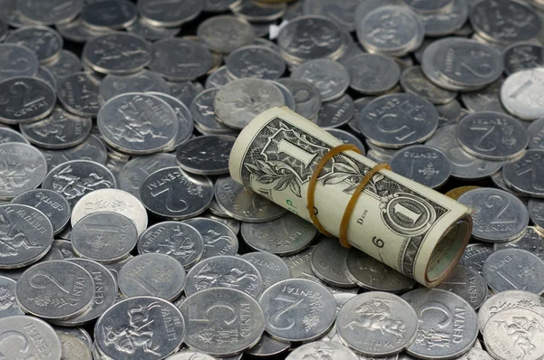 Rulle av en dollar räkningar på mynt bakgrund — Stockfoto