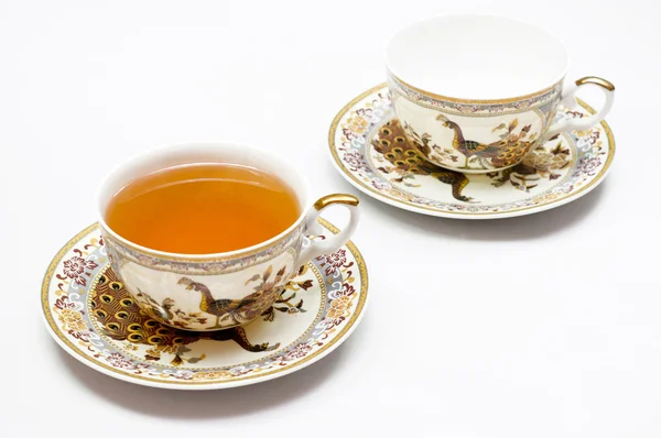 stock image Classic gold-rimmed china teacup and saucer. Isolated on white.