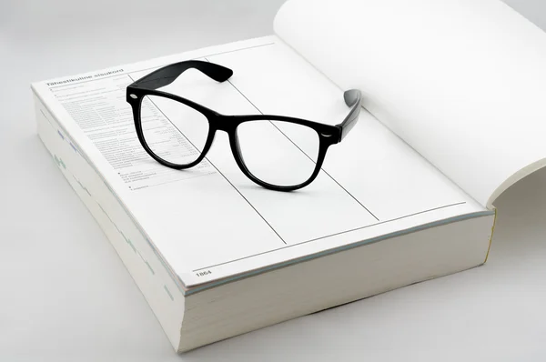 Bok och glasögon — Stockfoto