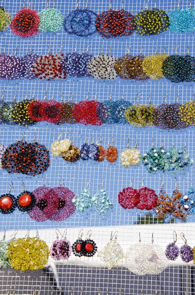 Muchos pendientes de colores hechos a mano venta feria del mercado —  Fotos de Stock