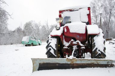 Old russian soviet tractor covered snow in winter clipart