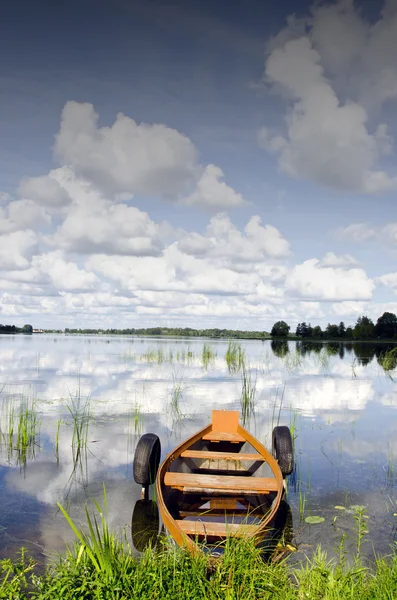 Sjön båt förtöjd däck moln reflektion på vatten — Stockfoto