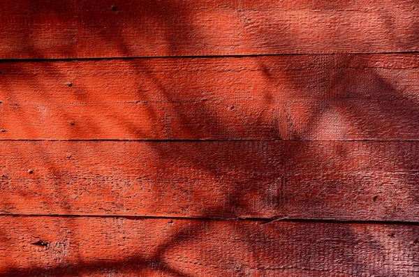 Skuggor på rödmålade trävägg. — Stockfoto