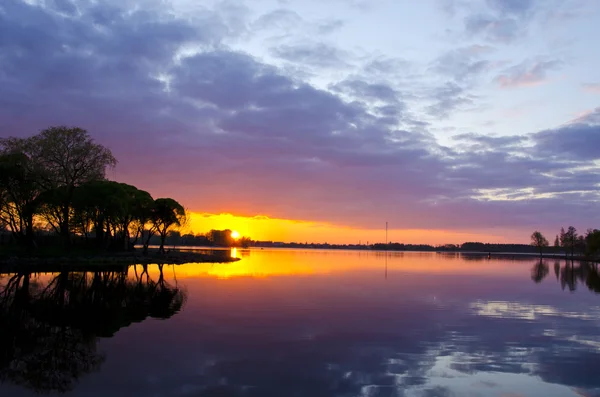 夏の湖の夕日。ボートの反射水空 — ストック写真
