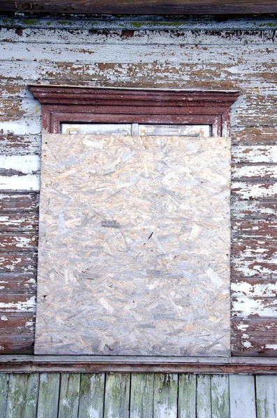Verlaten huis venster genageld-up hout spaanplaat — Stockfoto