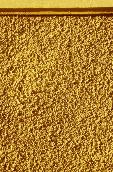 Mur texturé peint en jaune gros plan . — Photo