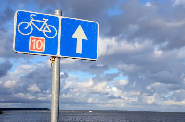 Знак велодорожки № 10 возле озера и облачного неба . — стоковое фото