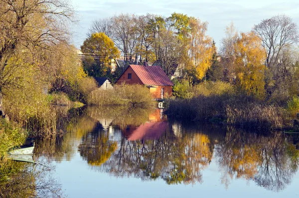 Casas de aldeia perto do rio. Outono árvores barco de água — Fotografia de Stock