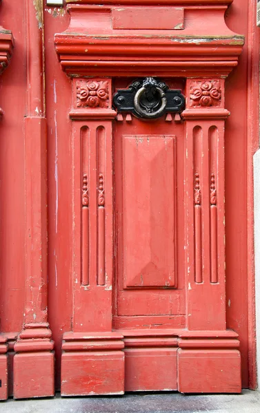 Винтажная красная деревянная дверь на фоне металлической ручки — стоковое фото