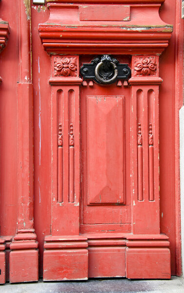 Vintage red wooden door with metal handle details background.