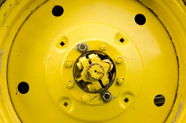 Amarelo trator roda closeup detalhes parafuso porca buraco — Fotografia de Stock