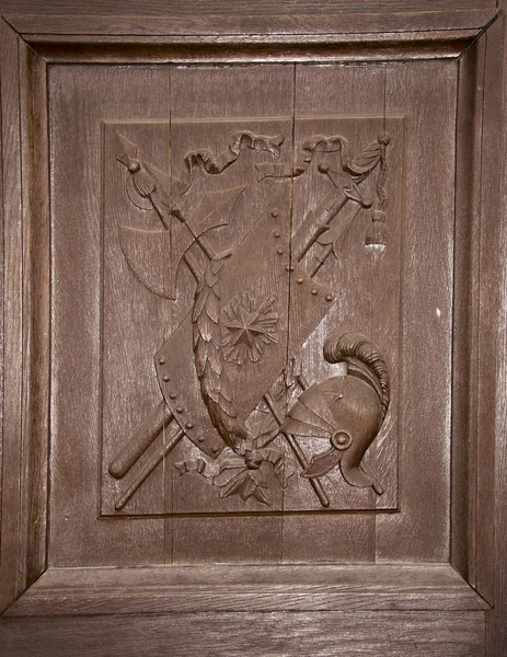 Drewniane rzeźbione drzwi herb hełm Tarcza miecze — Zdjęcie stockowe