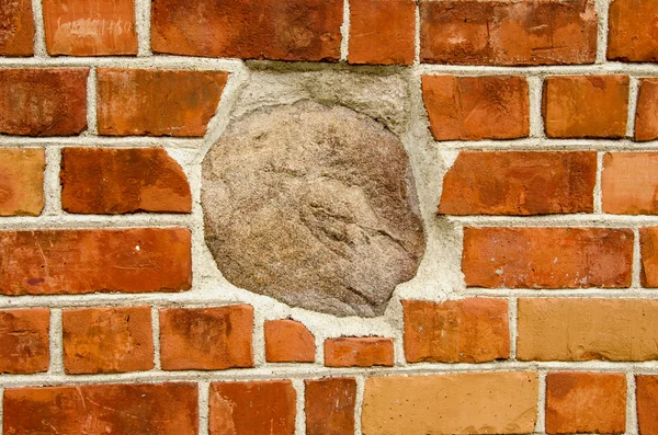 Duży kamień w czerwony mur z cegły. zbliżenie architektury — Zdjęcie stockowe