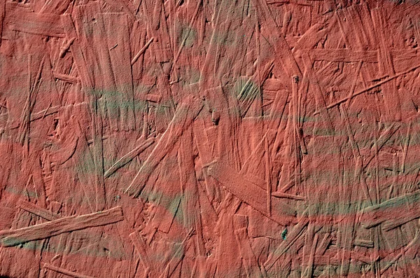 Grunge röda målade spånskiva närbild bakgrund — Stockfoto