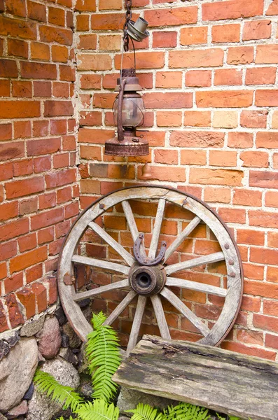 Rueda de carro de madera antigua y lámpara de querosina — Foto de Stock
