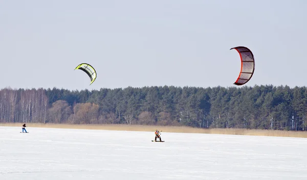 stock image Kiteboarding with snowboards frozen lake in winter