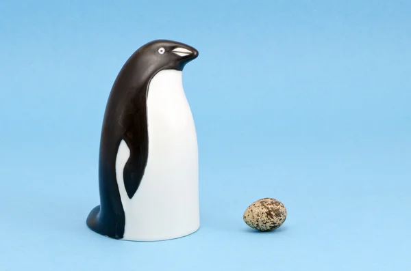 Pinguin-Vogel-Skulptur und Ei isoliert auf blau — Stockfoto