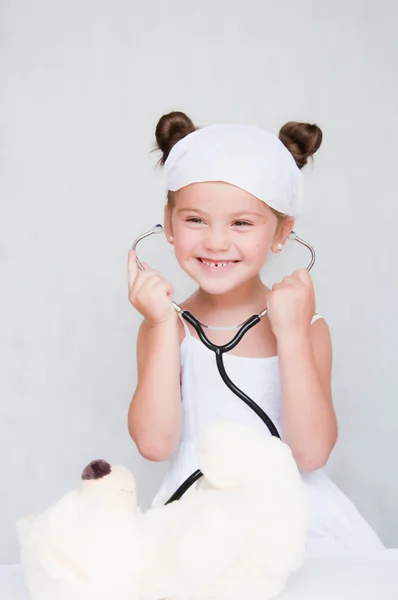 Маленькая девочка-доктор с плюшевым мишкой — стоковое фото
