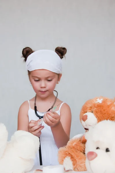 Маленькая девочка-доктор с плюшевым мишкой — стоковое фото