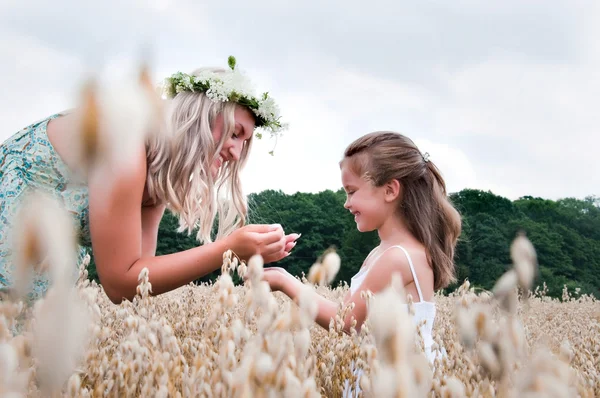 Mother and daughter playing at corn — Stock Photo, Image