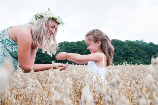 Mãe e filha brincando no milho — Fotografia de Stock