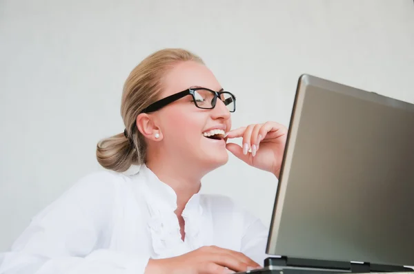 Atractiva joven mujer de negocios utilizando el ordenador portátil en el escritorio —  Fotos de Stock