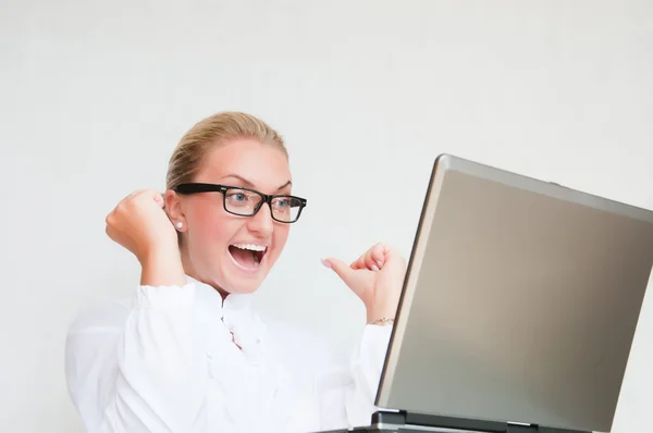 Atractiva joven mujer de negocios utilizando el ordenador portátil en el escritorio —  Fotos de Stock